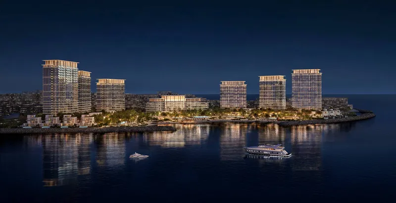 Render of the Address Al Marjan Island towers lit at night across the water