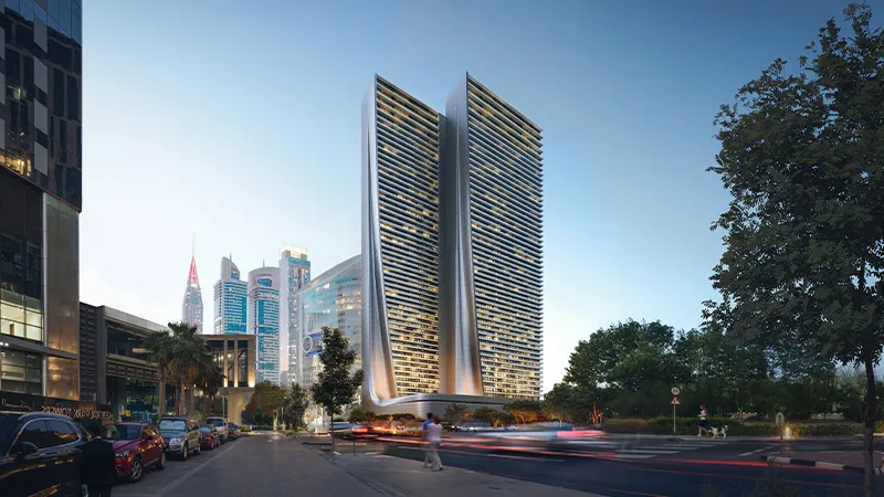 Dusk render of the Akala towers seen from a tree-lined street, with the podium entrance lit at ground level