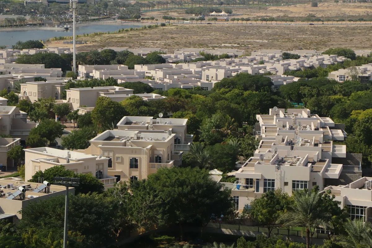 Aerial view of villas and townhouses among trees in a Dubai residential community