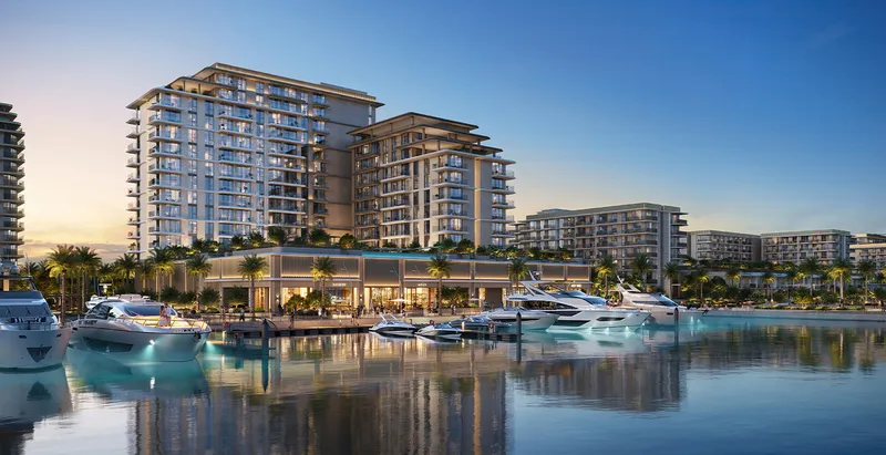 Render of the Aurea buildings at dusk rising above yacht berths at Rashid Yachts & Marina