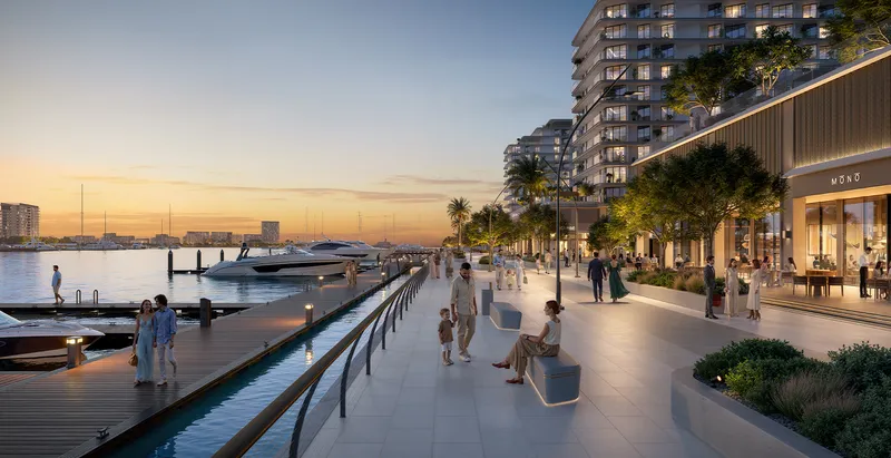 Render of the Marina Promenade at sunset with shopfronts, palm trees and moored yachts beside Aurea