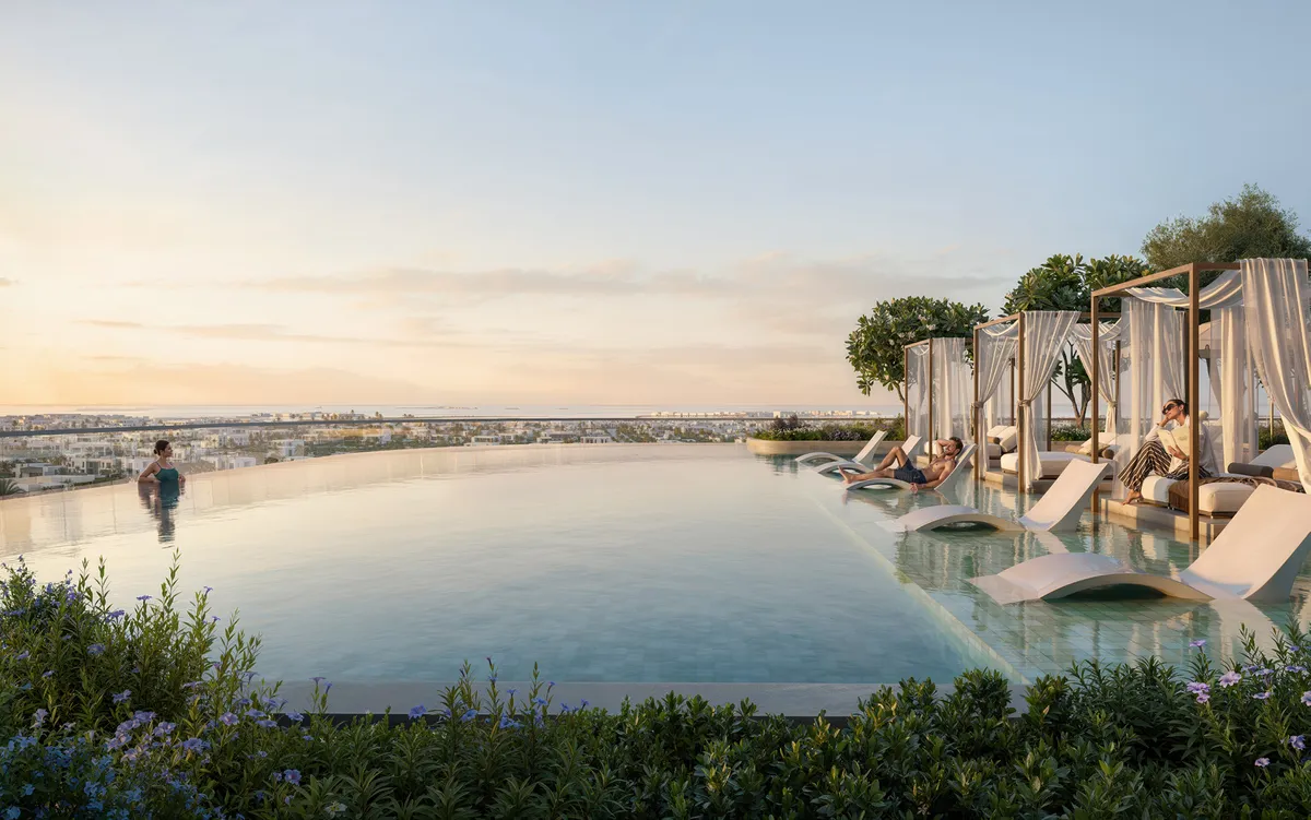 Render of an infinity pool with cabanas and loungers overlooking the city at sunset