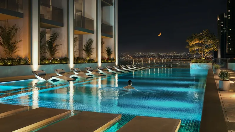 Render of the swimming pool and loungers on the Binghatti Etherea amenity deck at night