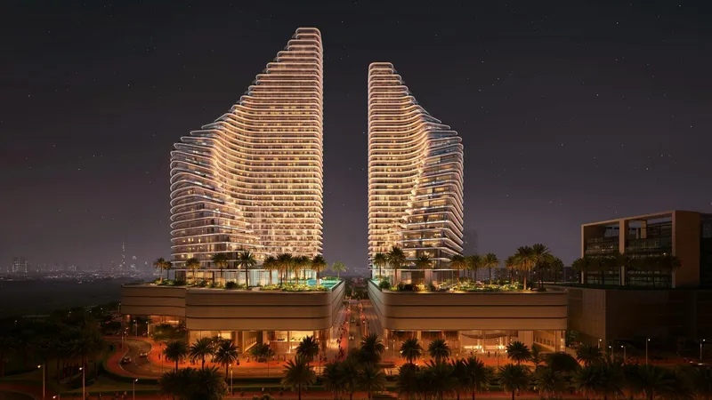 Render of the Binghatti Flare towers lit at night above their landscaped podium