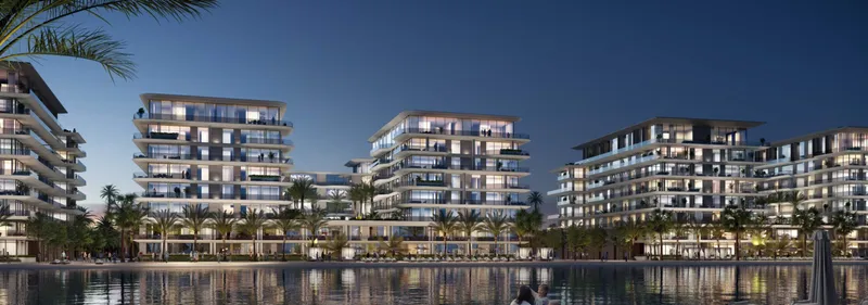 Blue Beach Residence buildings lit at dusk across the water