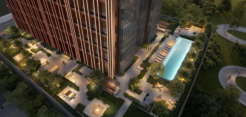 Aerial view of the Burj Capital podium with a lit pool, seating areas and gardens