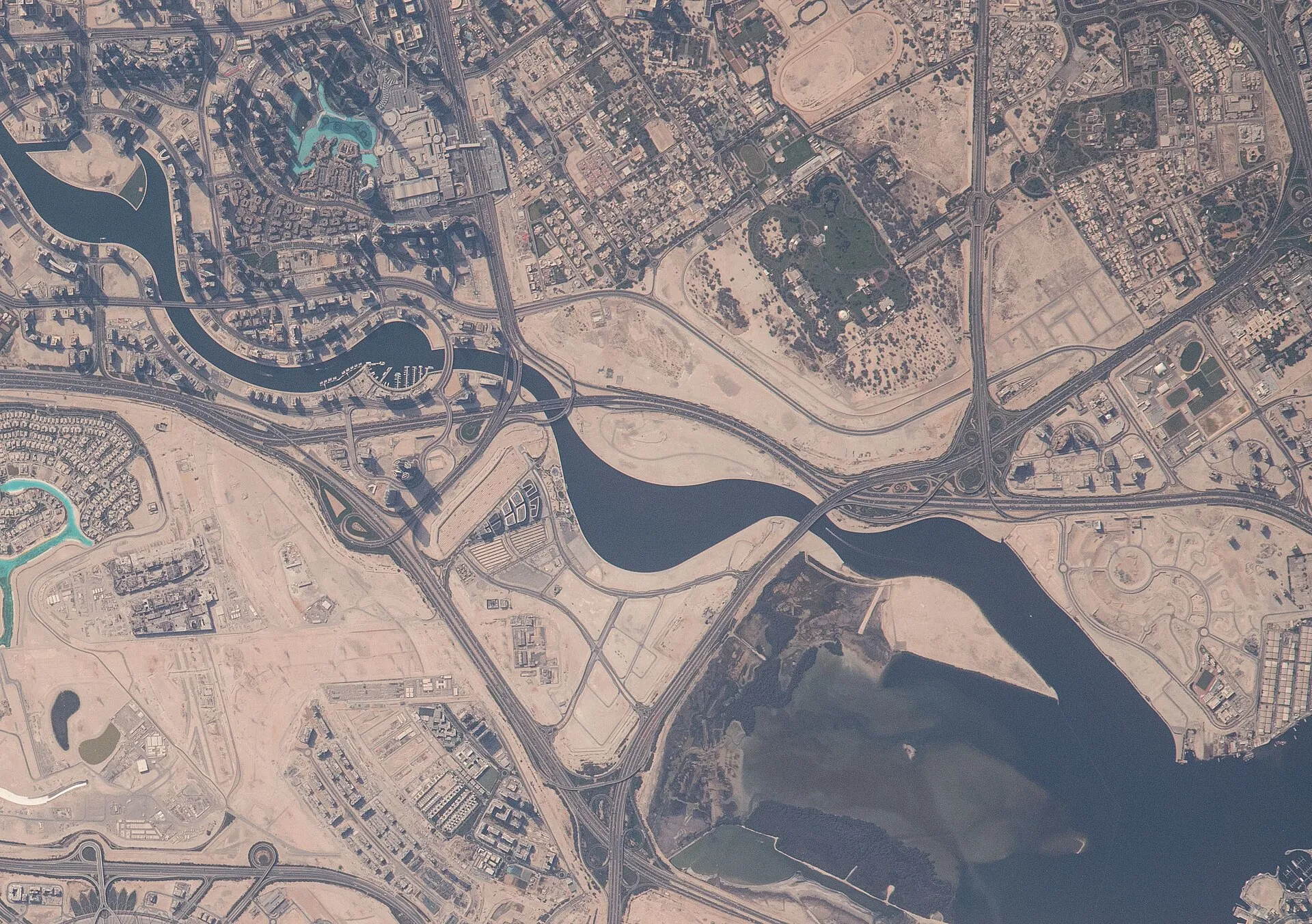 Satellite photograph of Dubai from the International Space Station showing the Dubai Water Canal, the Business Bay tower cluster and the Ras Al Khor wetlands