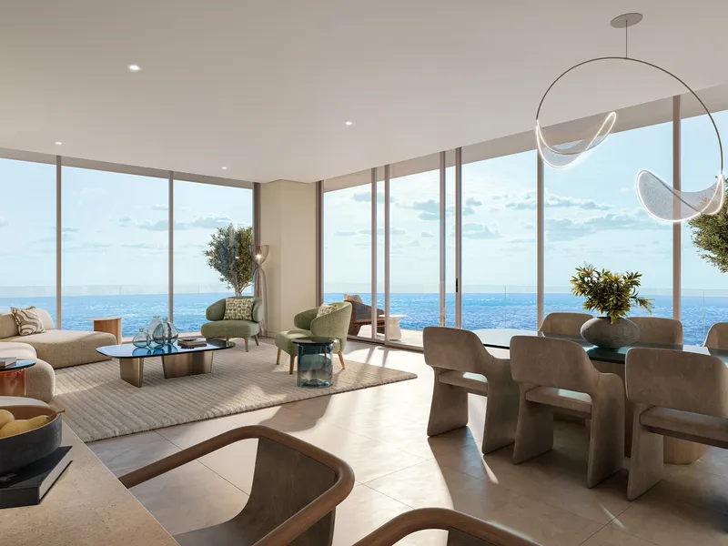 Living and dining room at Chelsea Residences with floor-to-ceiling windows facing the sea