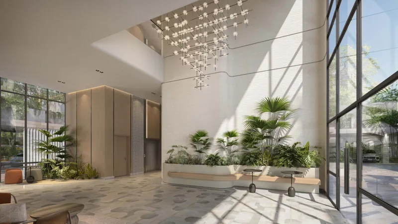 Double-height Cilia lobby with a chandelier and indoor planting
