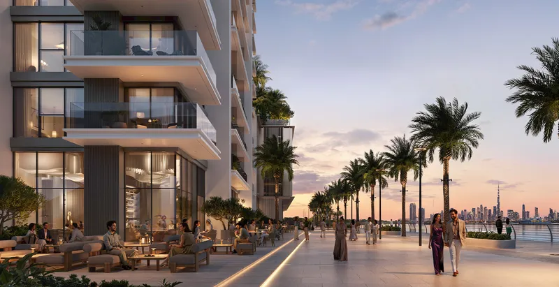 Render of the palm-lined waterfront promenade and ground-floor cafés at Creek Bay at sunset