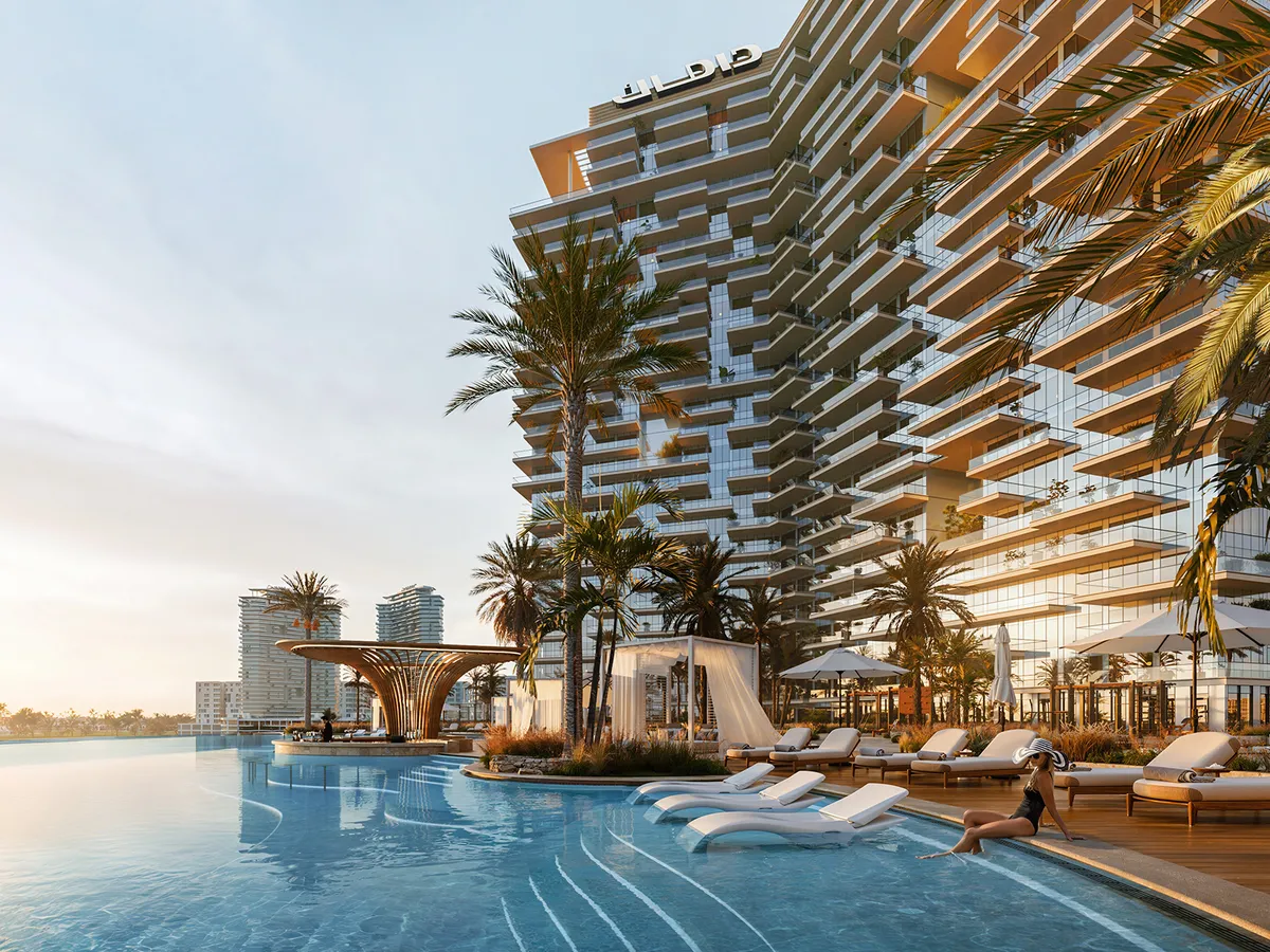 Infinity pool with loungers and a shaded bar at the foot of a DAMAC District tower