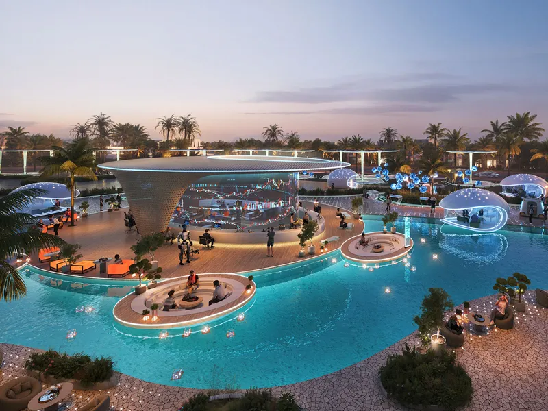 Pool with lit seating islands and a canopy at DAMAC Islands 2 in the evening
