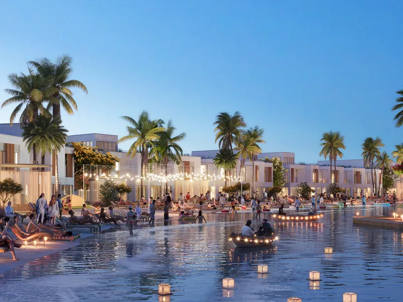 Floating lanterns and boats on the river in front of DAMAC Riverside townhouses in the evening