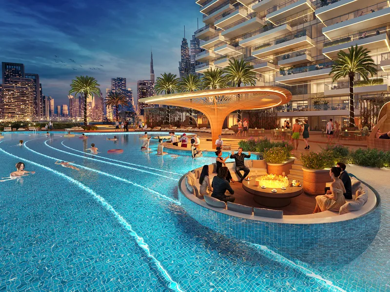 Illuminated pool deck at Safa Gate at night with a sunken seating island and the city skyline