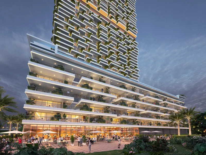 Stepped, planted terraces at the base of Safa Gate at dusk, with outdoor dining at ground level