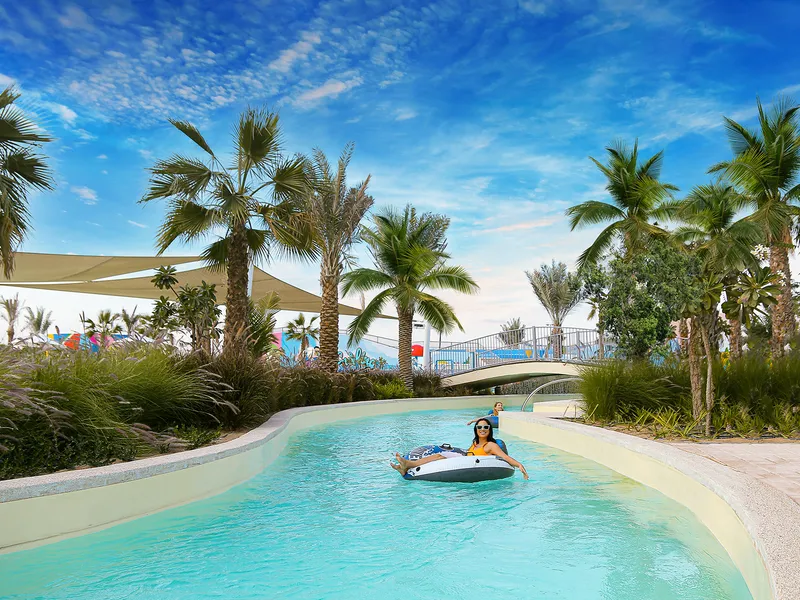 Lazy river lined with palm trees in DAMAC Hills 2