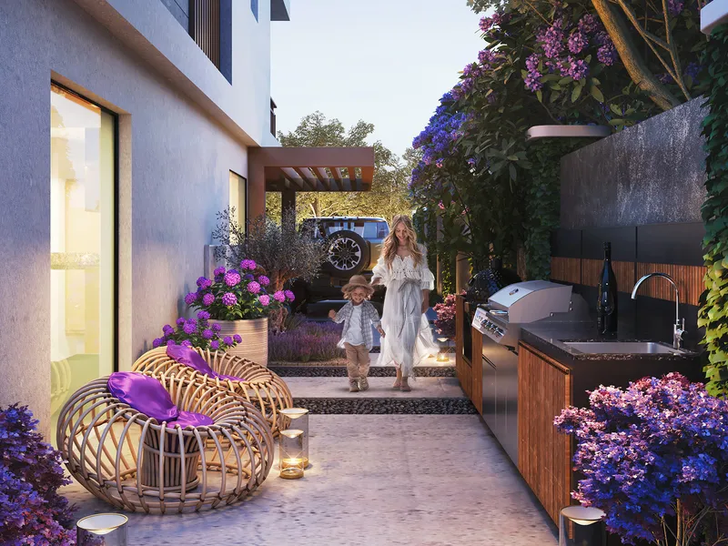 Paved garden courtyard beside a Violet 4 townhouse with an outdoor kitchen counter and seating