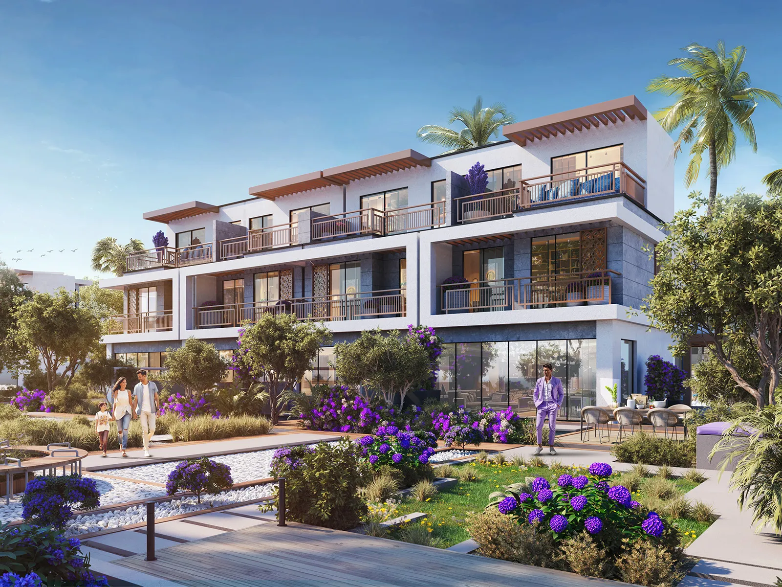 Row of three-storey Violet 4 townhouses with balconies and rooftop terraces behind a landscaped garden in DAMAC Hills 2