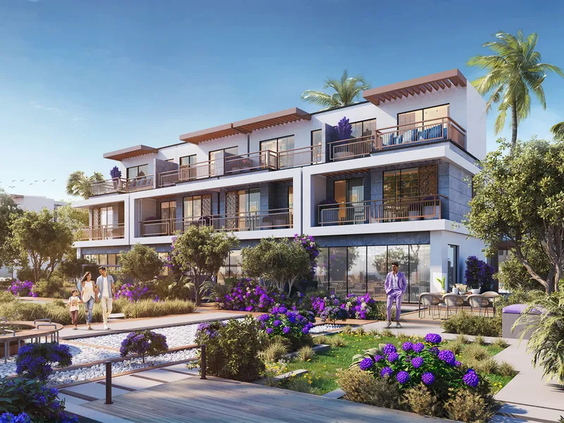 Row of three-storey Violet 4 townhouses with balconies and rooftop terraces behind a landscaped garden in DAMAC Hills 2