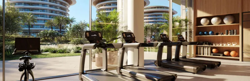 Render of the residents' gym at The Residences at The Dubai Beach EDITION, with treadmills facing gardens and the towers