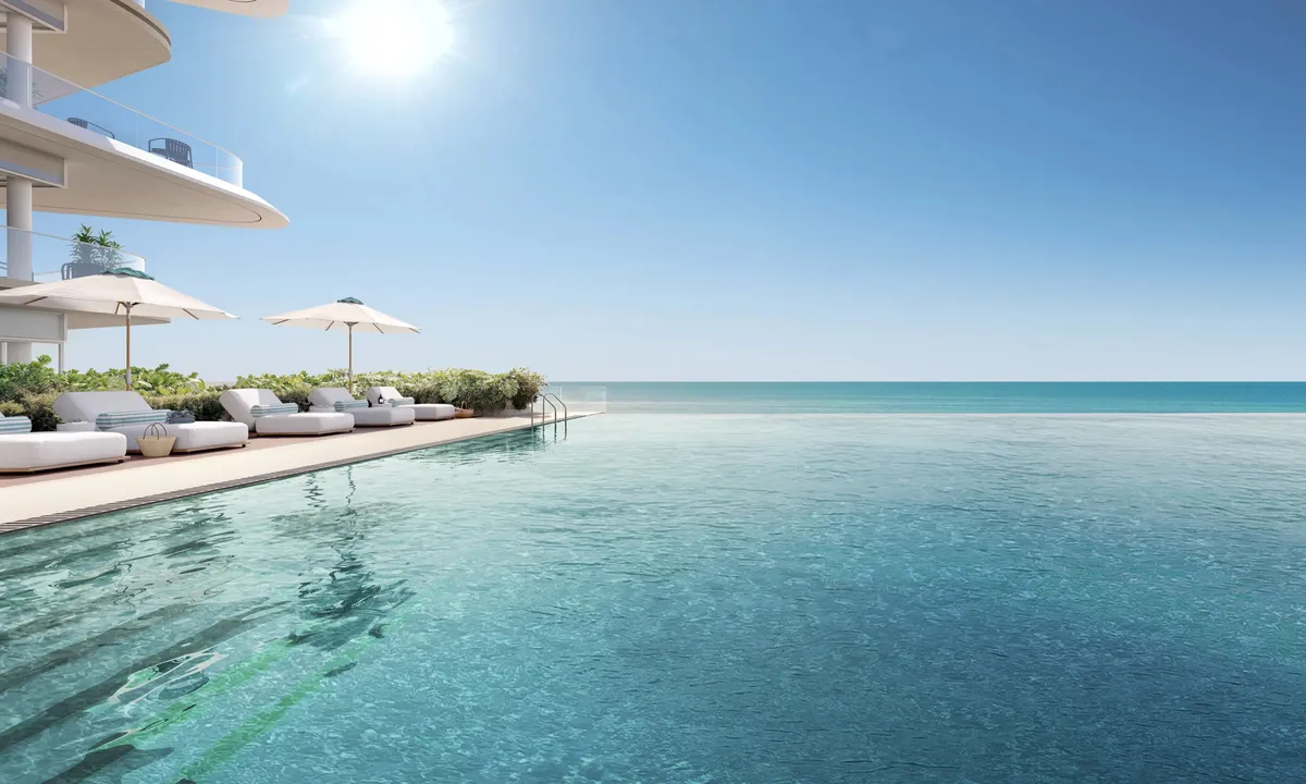 Render of the podium infinity pool at Fahid Beach Residences with loungers and parasols, the sea beyond