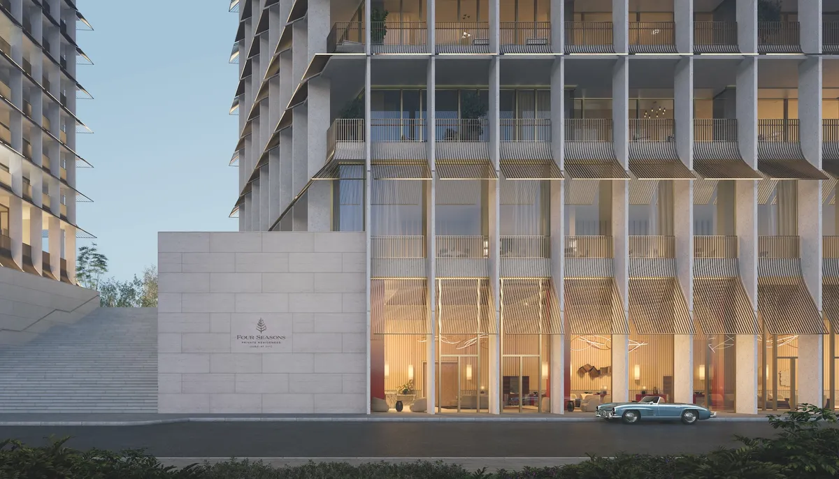 Render of the arrival court at Four Seasons Private Residences Dubai at DIFC, with the tower's slatted facade above a stone entrance wall
