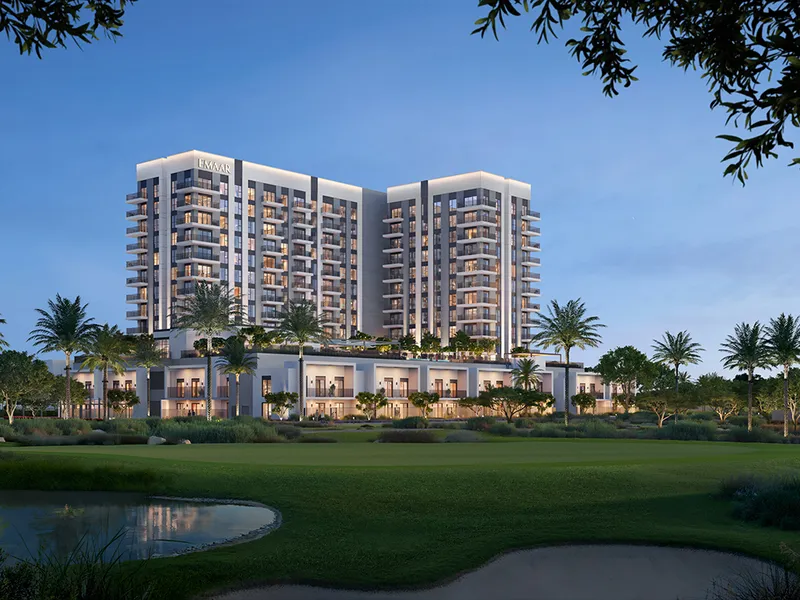 Render of the Golf Fields buildings at dusk seen across the golf course and a water feature