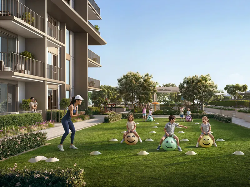 Render of residents playing on a landscaped lawn beside a Golf Trails building at Emaar South.