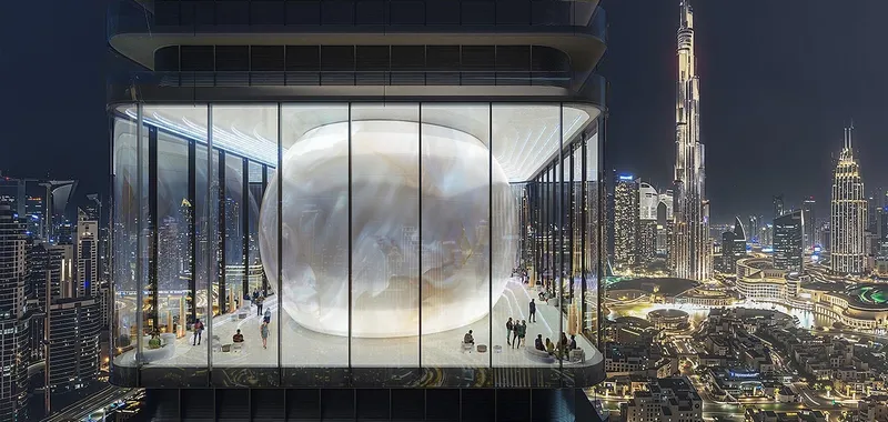 Night render of the glass-walled orb level inside Inaura Downtown, with Burj Khalifa beyond