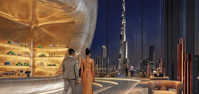 Render of the Sky Lounge at Inaura Downtown with a curved gold wall and floor-to-ceiling windows facing Burj Khalifa at night