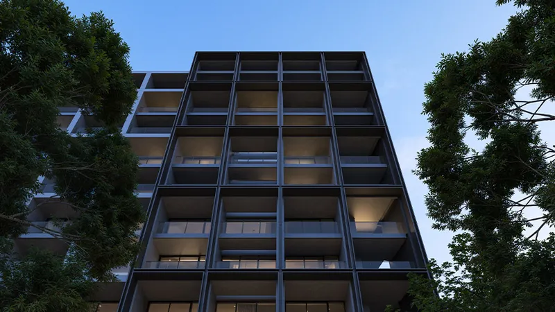 Render looking up at the dark grid facade and recessed balconies of a Jenna building at Aljada, framed by trees