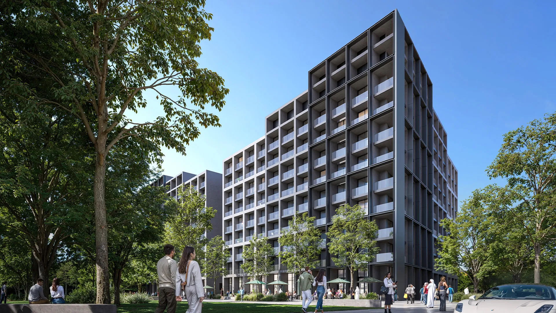 Render of the Jenna apartment buildings at Aljada seen from a tree-lined path on West Boulevard, with people walking below