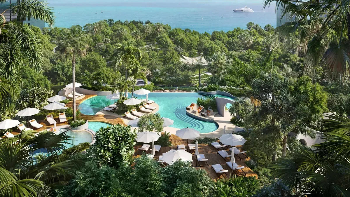 Pool deck set in forest landscaping at Kanyon, with the sea beyond