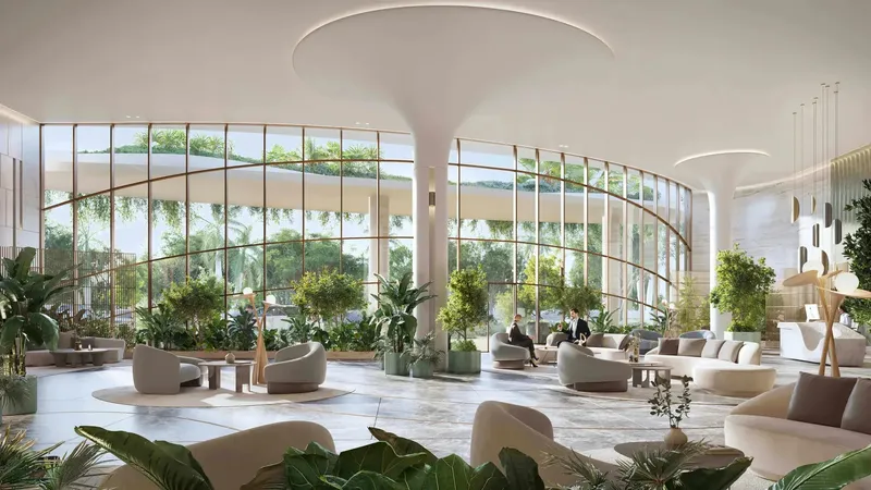Glass-enclosed grand lobby with planting and lounge seating at Kanyon