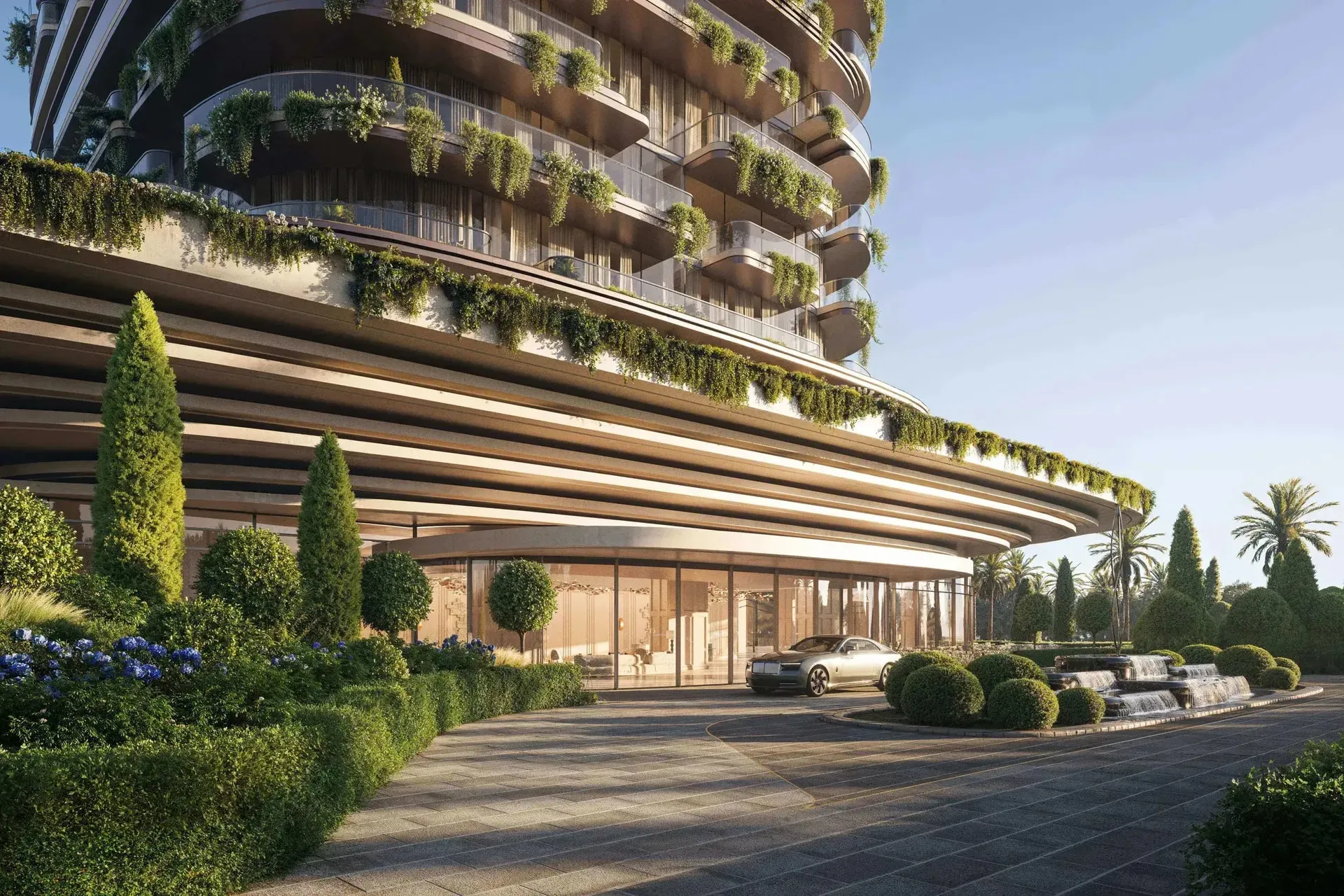 Arrival court beneath the curved podium of Le Château by BEYOND, with planted balconies above