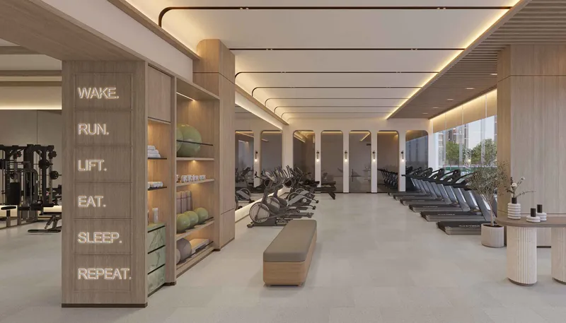 Residents gym at Expo Valley Views with cardio equipment and a neon wall