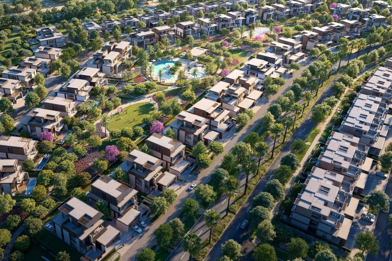 Aerial render of Nad Al Sheba Gardens showing a community pool and open lawn between villa and townhouse streets, with palm lined avenues