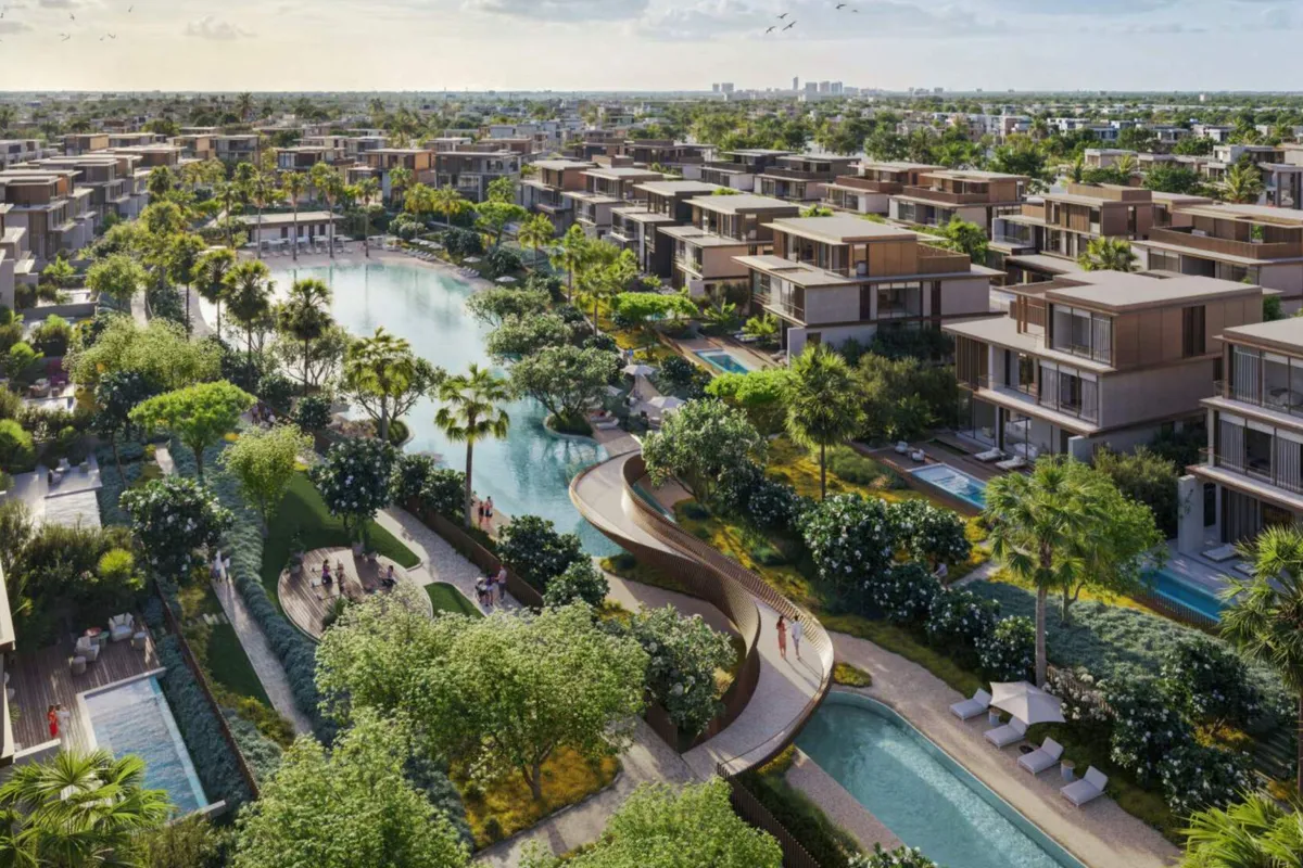 Render of the Nad Al Sheba Gardens wave pool and lagoon, with a curved bridge and villas with private pools alongside