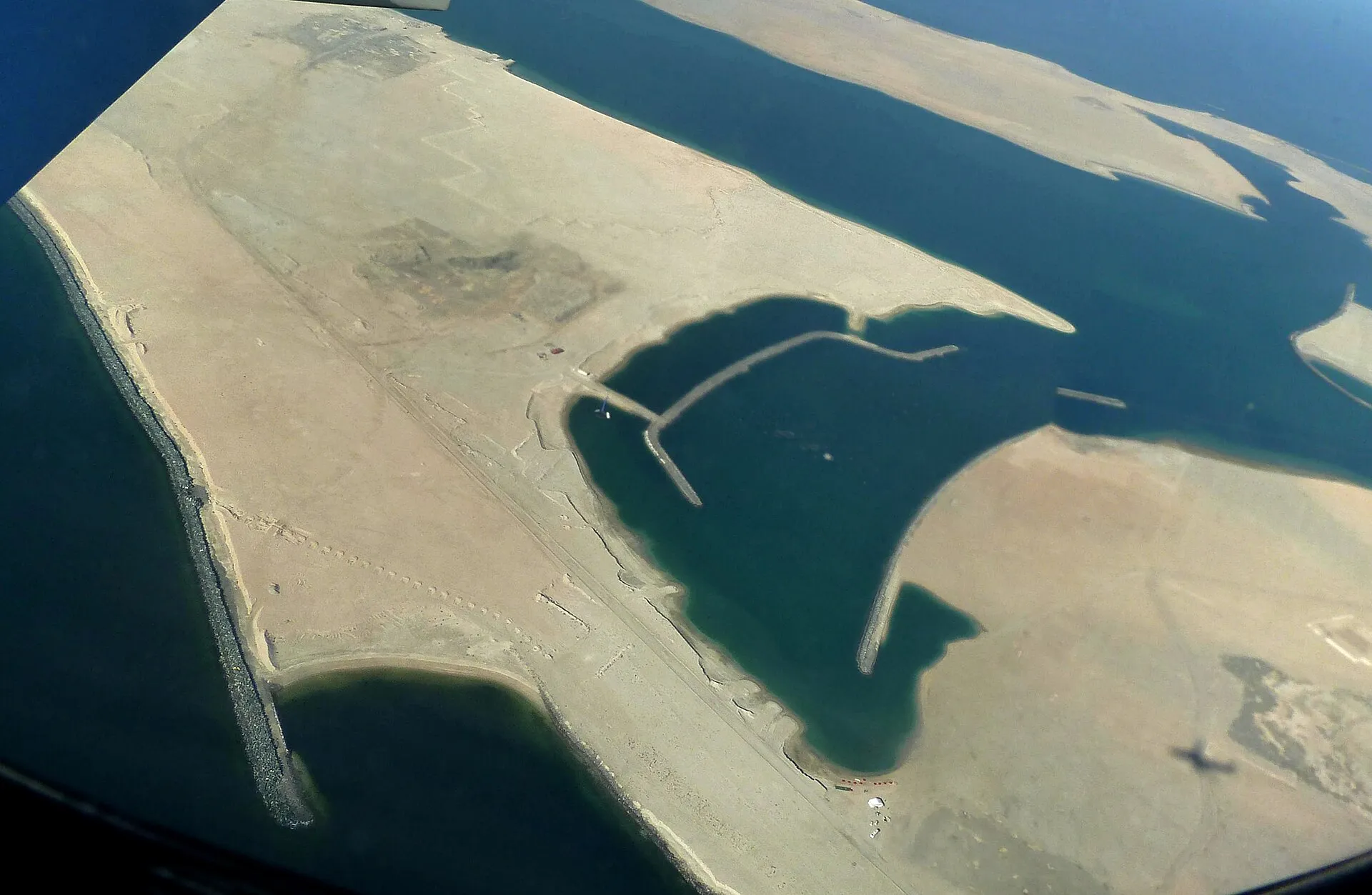 Aerial view of the reclaimed Dubai Islands off Deira, still bare sand with breakwaters and channels cut between the islands.