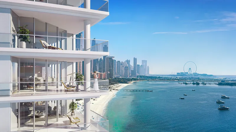 Curved balconies at Palm Beach Towers overlooking the beach, with Dubai Marina and Ain Dubai in the distance
