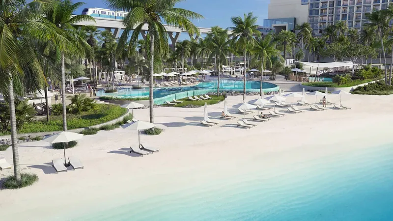 Residents' beach with loungers, palms and pools at the foot of Palm Beach Towers