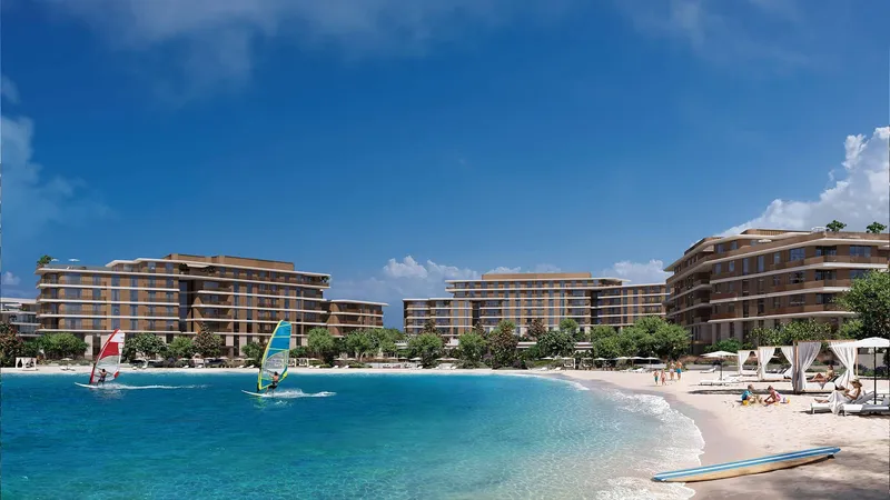 Palm Central Private Residences stepped buildings behind a sandy beach with windsurfers