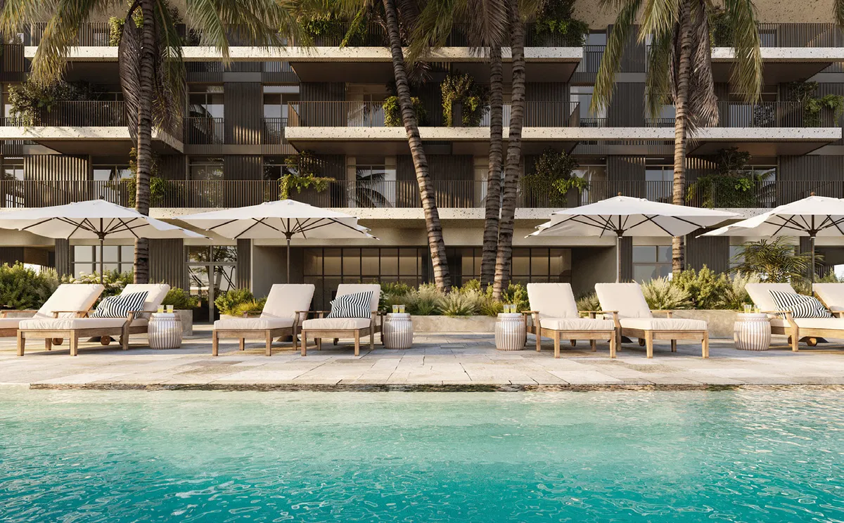 Render of a Rise by Athlon pool deck with sun loungers and parasols below palm trees and apartment balconies