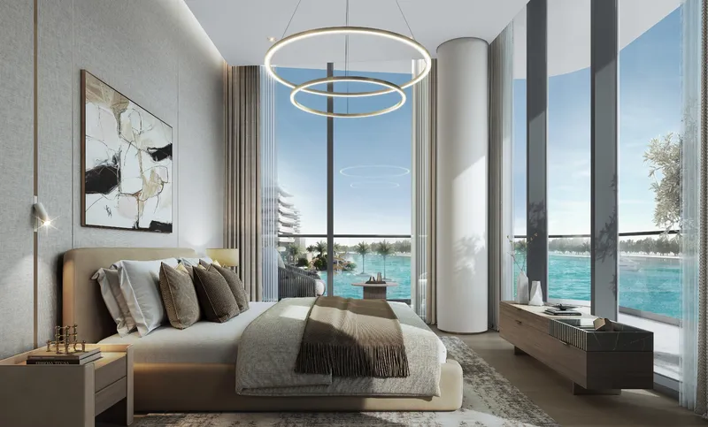 Bedroom with full-height windows looking over the water at River Cove Residences