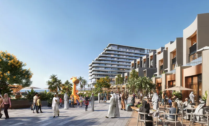 Waterfront promenade with cafés below the River Cove Residences towers