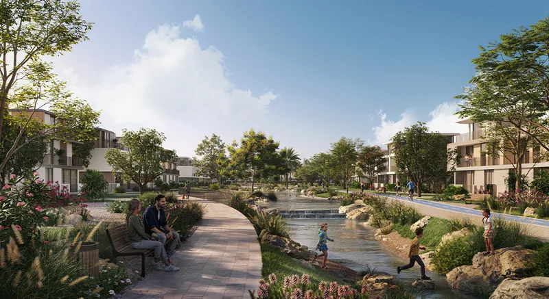Render of a paved walk beside a shallow stream running between Rivera townhouses