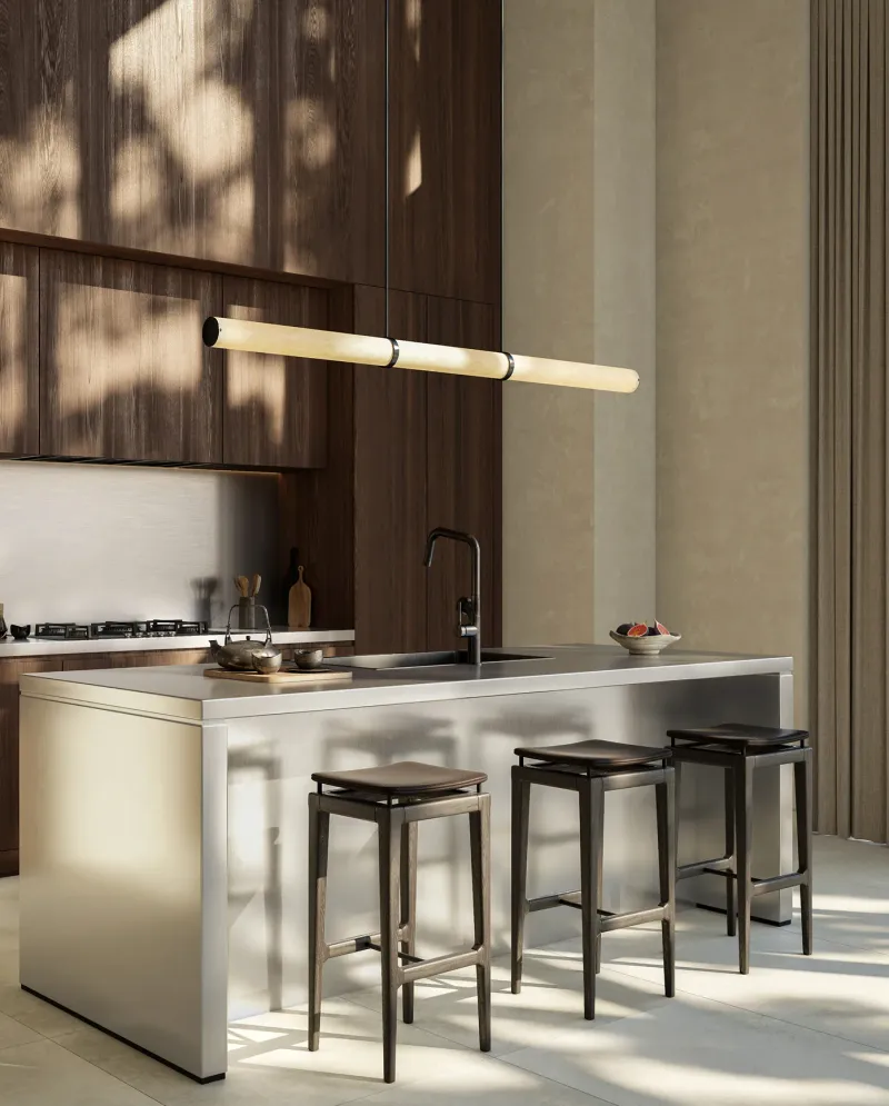 Render of a Sei Saadiyat kitchen with dark timber joinery, a stone topped island with three stools, a gas hob and a linear pendant light.