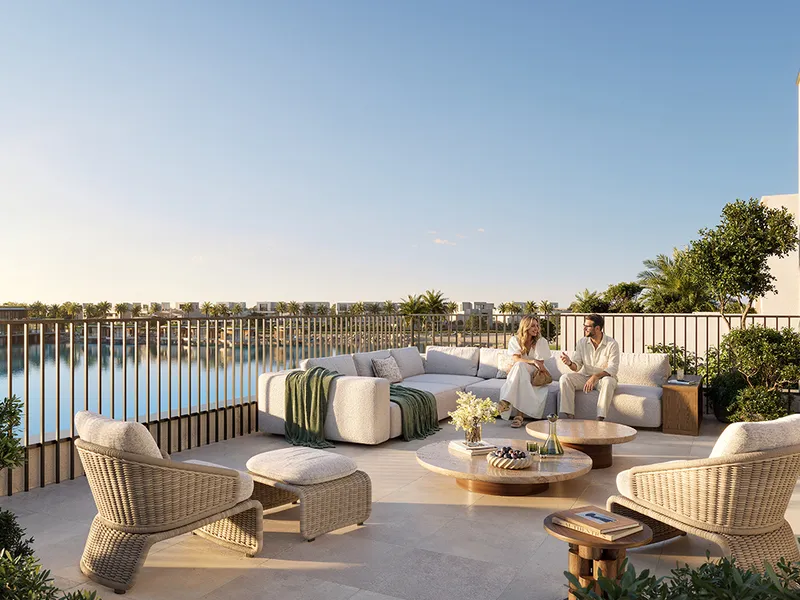 Render of an outdoor lounge terrace with armchairs and a sofa overlooking a lake