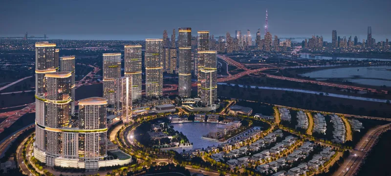Aerial render of Sobha Hartland II at dusk, with towers around the crystal lagoons, the villa districts and the Downtown Dubai skyline behind
