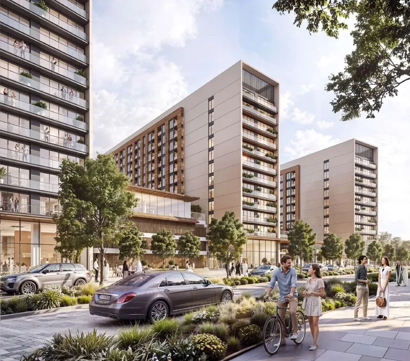 Street view of The Woods Abode at Sobha Sanctuary, mid-rise residential buildings with planted terraces and a landscaped boulevard